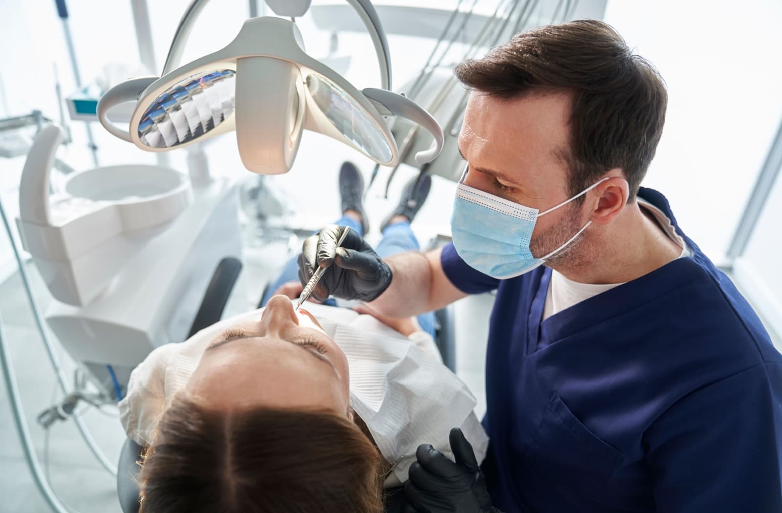 A dentist evaluating their patients' oral health during a dental exam.